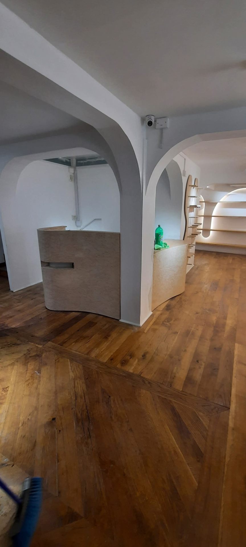 Local comercial con arcos de yeso y piso de madera restaurado